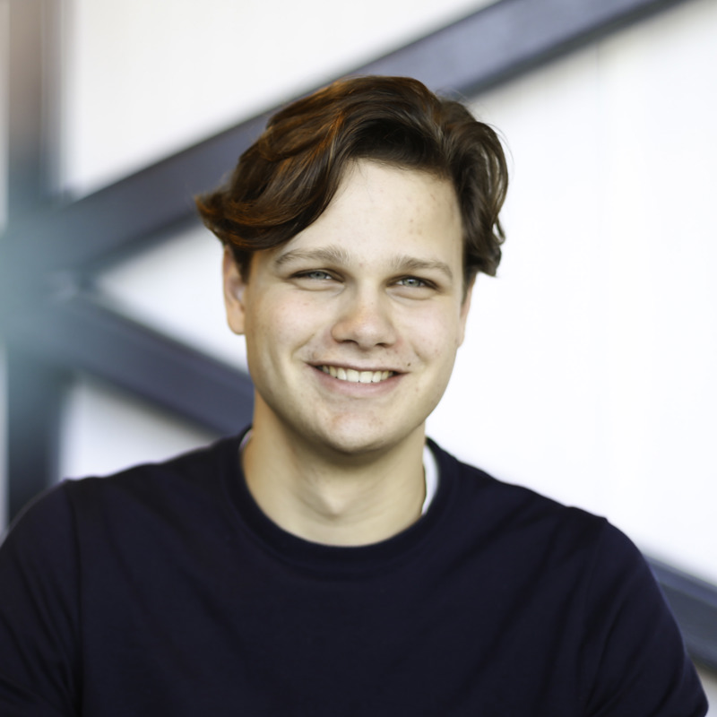 Willem Veldhuizen, stagiair bij Ballast Nedam Digitalisering en Innovatie, glimlachend in zijn kantoor in Nieuwegein