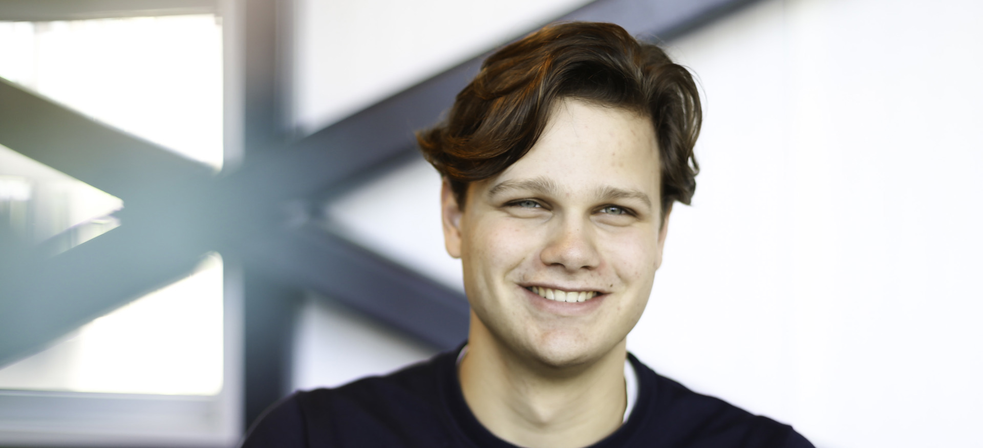 Willem Veldhuizen, stagiair bij Ballast Nedam Digitalisering en Innovatie, glimlachend in zijn kantoor in Nieuwegein